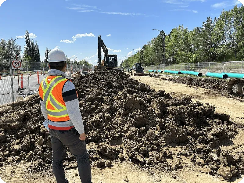 Crewscope site supervisor observing excavation and earth-moving on a sunny day